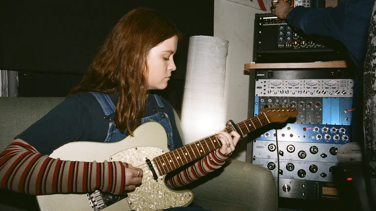 claudia fenoglio plays an electric guitar