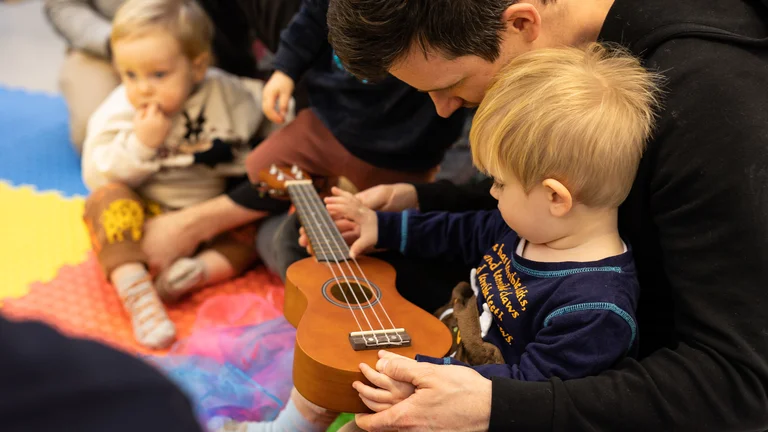 A father with a baby and a guitar