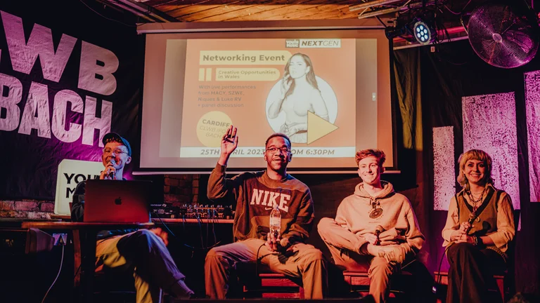 a panel of young creatives sit on stage