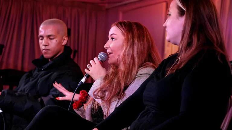 jasmine rowland holds a microphone and speaks on a panel