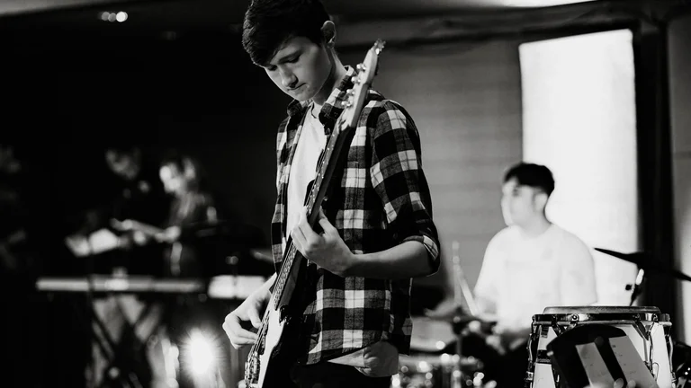 boy playing guitar in a band