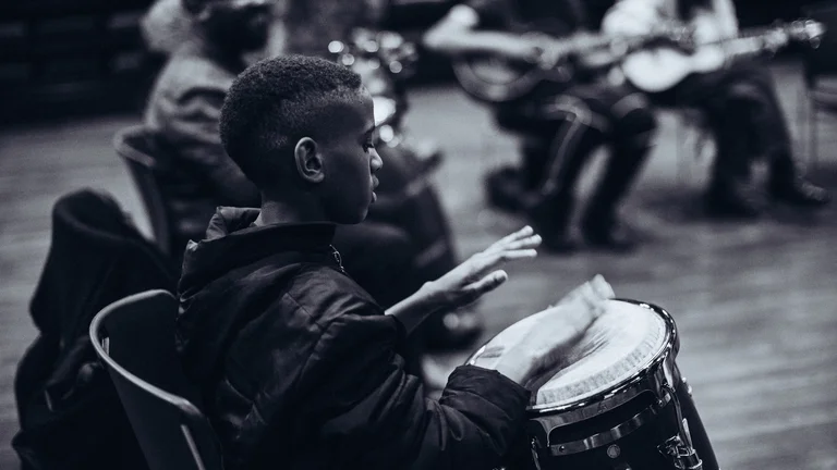 Young boy playing the drums in a group