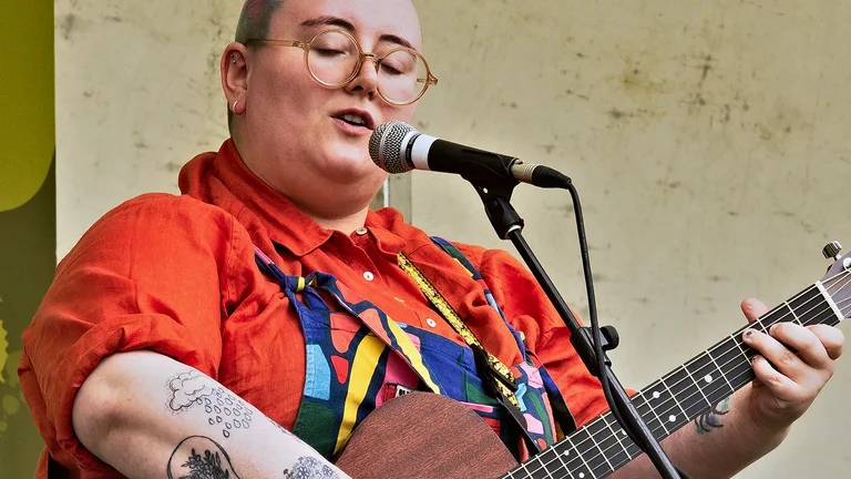 Maddie morris playing guitar and singing on stage