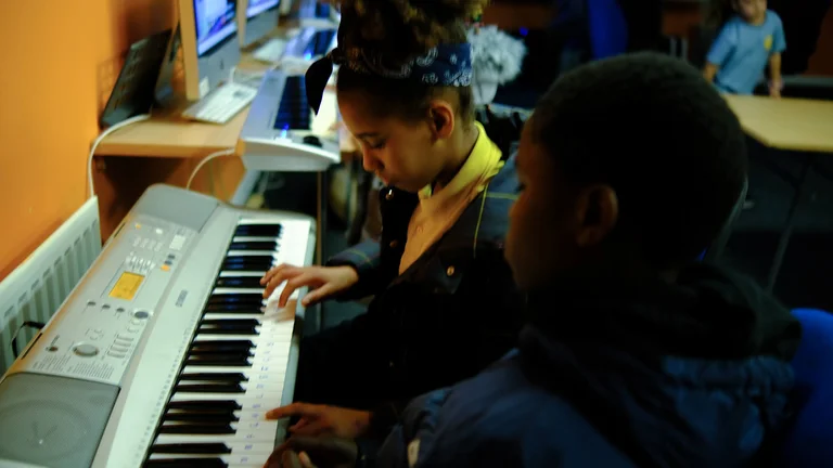 two children play the keyboard