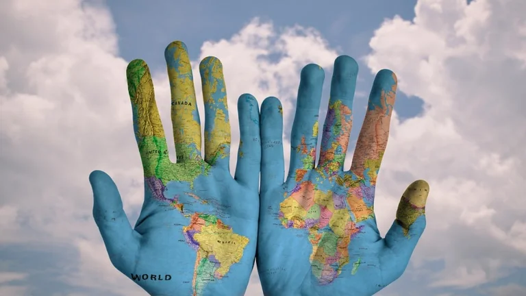 A world map painted on the palms of hands