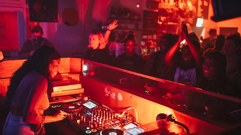 a dj plays to an enthusiastic crowd in an intimate club setting