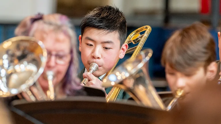 Boy playing the trumpet in an orchestra