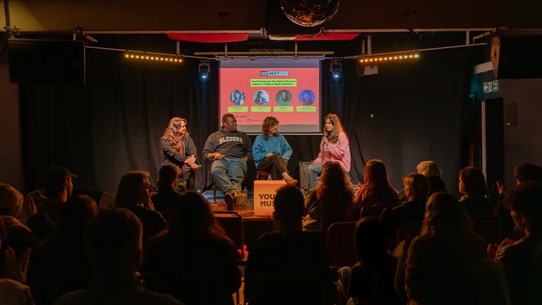 the panel on stage, watched by the audience