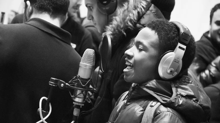 young person with headphones on singing into a mic