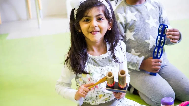 young girl with instruments in her hand smiling