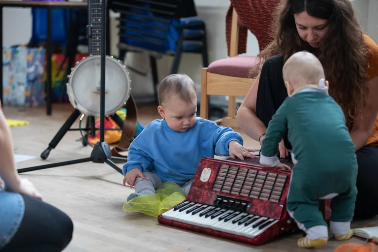 two babies playing musical instruments