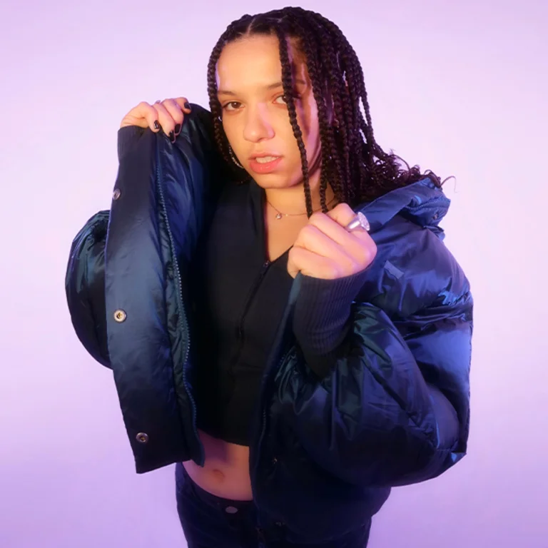 a woman with braids wears a dark puffer jacket