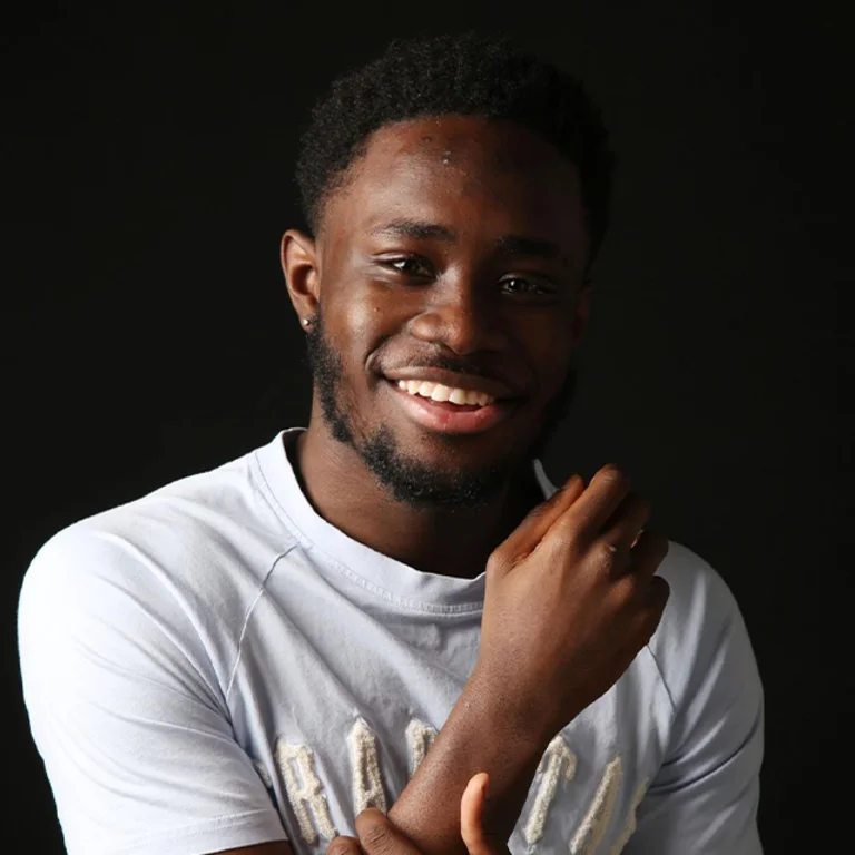 a man wears a white t shirt and smiles