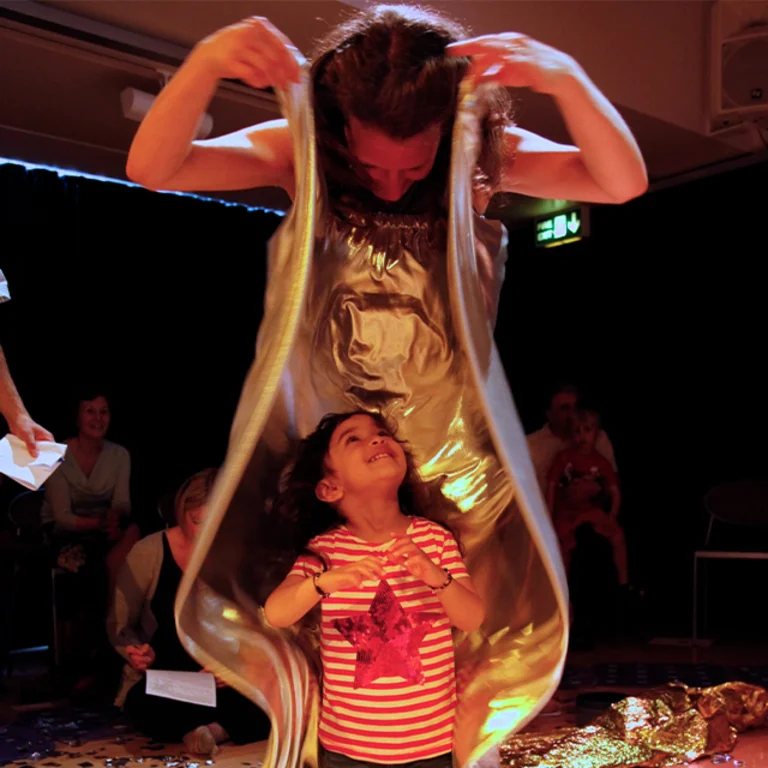 young girl playing with sensory materials with an adult