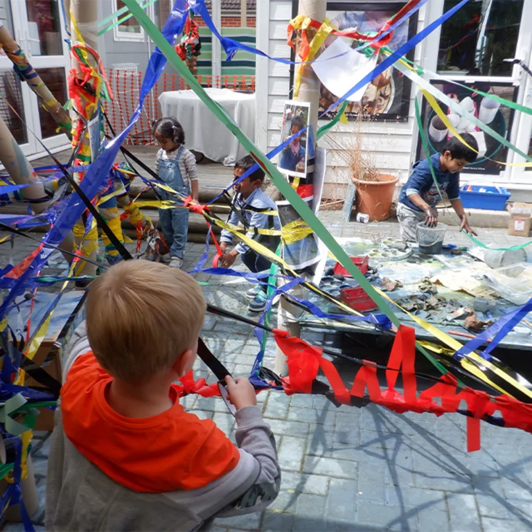 Children playing in a playground with colourful paper chains